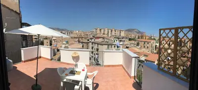 a balcony with a table and chairs and a view of a city at Frank's house - appartamento con terrazzo in centro in Palermo