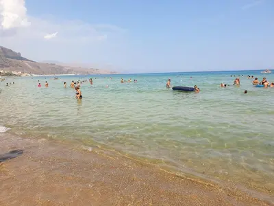 a group of people in the water at the beach at Castellammare Holiday in Alcamo Marina