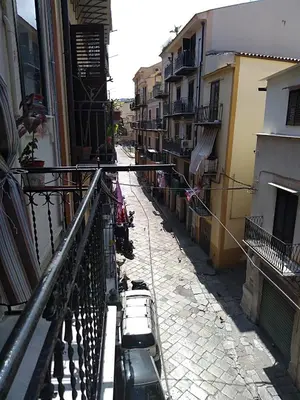 a narrow street with buildings and a balcony at Casa Albergheria in Palermo