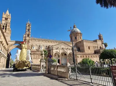 a building with a statue in front of a fence at Casa Albergheria in Palermo