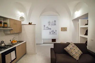 a kitchen and a living room with a couch at Via Vittorio Emanuele Apartment in Palermo