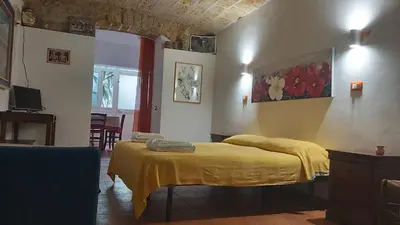 a bedroom with a yellow blanket on a bed at vibavacanze in Palermo