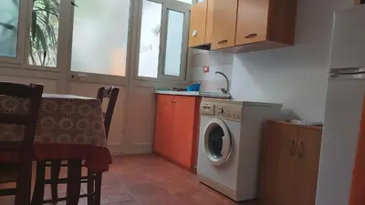 a kitchen with a washing machine next to a table at vibavacanze in Palermo