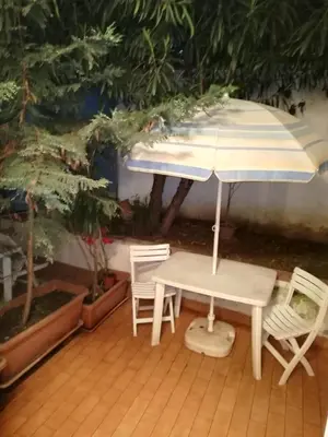 a table and chairs and an umbrella on a patio at vibavacanze in Palermo