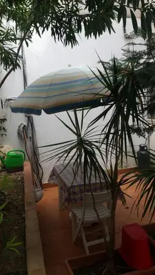 a chair under an umbrella next to a table at vibavacanze in Palermo