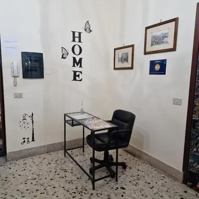 a glass table and a chair in front of a wall at Arco di Trionfo Palermo Bed & Breakfast in Palermo
