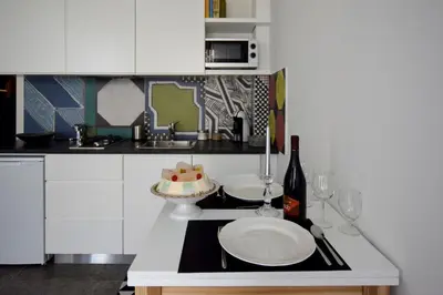 a kitchen with a table with a cake and wine glasses at Teatro Massimo Cool Home in Palermo