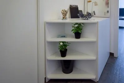 a white shelf with two potted plants on it at Teatro Massimo Cool Home in Palermo