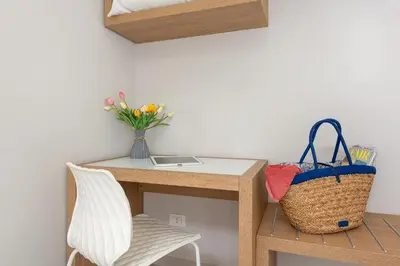 a desk with a vase of flowers and a chair at Residence Le Piscine in San Vito lo Capo