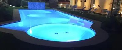 a large swimming pool with blue lighting in a building at Residence Le Piscine in San Vito lo Capo