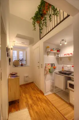 a kitchen with white walls and wooden floors at Natoli Apartments in Palermo