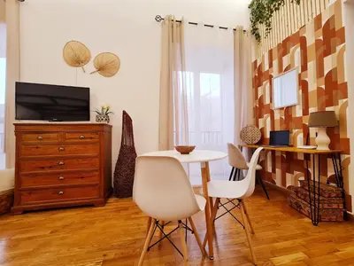 a living room with a table and chairs and a tv at Natoli Apartments in Palermo