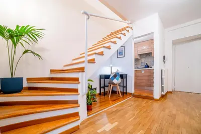 a staircase in a living room with wooden floors and white walls at Natoli Apartments in Palermo