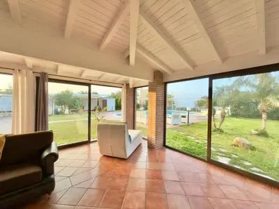 a living room with a couch and chairs and windows at Villa Cocus in Altavilla Milicia