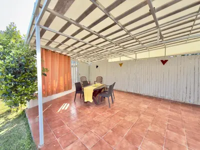 a patio with a table and chairs under a pergola at Villa Cocus in Altavilla Milicia