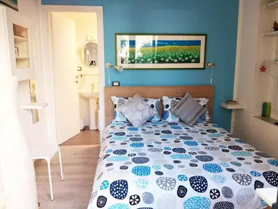 a bedroom with a bed with a blue wall at Il Giardino di Laura Private Rooms Mondello in Mondello