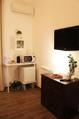 a living room with a table and a microwave at Il Giardino di Laura Private Rooms Mondello in Mondello