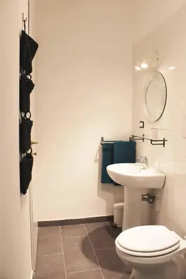 a bathroom with a white toilet and a sink at Il Giardino di Laura Private Rooms Mondello in Mondello