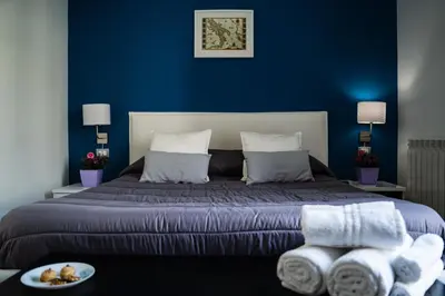 a bedroom with a large bed with blue walls at Le Due Sicilie B&B in Lascari