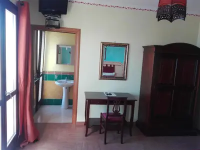 a bathroom with a table and a sink and a mirror at B&B Donna Sabella in Santa Flavia