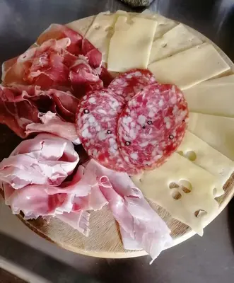 a plate of different types of meat and cheese at B&B Donna Sabella in Santa Flavia