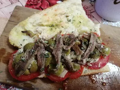 a pizza with meat and peppers on a cutting board at B&B Donna Sabella in Santa Flavia