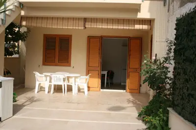 a patio with a table and chairs in front of a house at Appartamento casa mare in Alcamo Marina