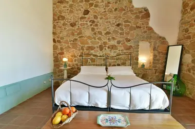 a bedroom with a bed with a stone wall at Terre Di Himera in Buonfornello