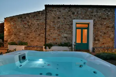 a bath tub in front of a brick building with a door at Terre Di Himera in Buonfornello