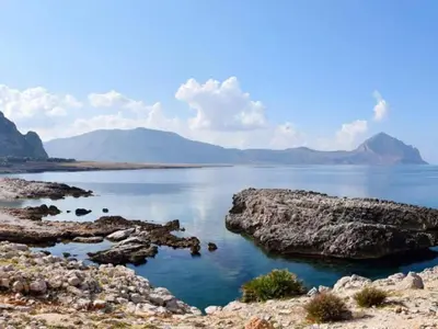 a large body of water with mountains in the background at Appartamenti Irene in Macari