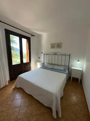 a bedroom with a large bed and a window at Appartamenti Irene in Macari