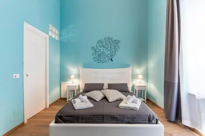 a bedroom with a large bed with blue walls at SheralKes Bed&Breakfast in Palermo