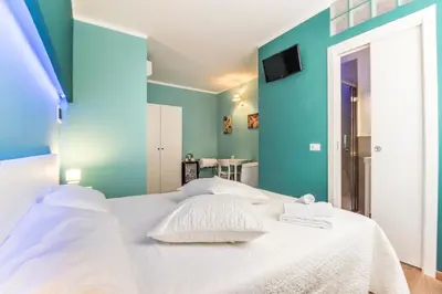 a bedroom with a white bed with blue walls at SheralKes Bed&Breakfast in Palermo