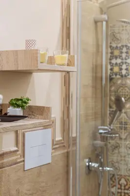 a bathroom with a shower with two glasses on a shelf at Il Tempo Ritrovato - Locazione ad uso turistico in Palermo