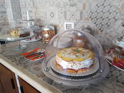 a cake in a glass case on a counter at B&B Aloe Comfort Rooms in San Vito lo Capo