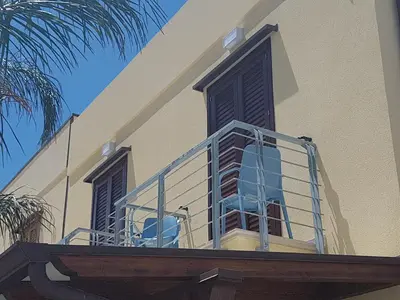 a balcony with blue chairs on a building at B&B Aloe Comfort Rooms in San Vito lo Capo