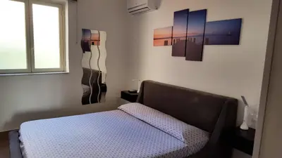 a bedroom with a bed and paintings on the wall at Le Torri dell'acqua in Palermo