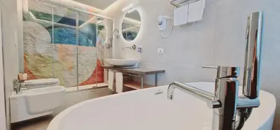 a bathroom with a white sink and a toilet at Saracen Sands Hotel & Congress Centre - Palermo in Isola delle Femmine
