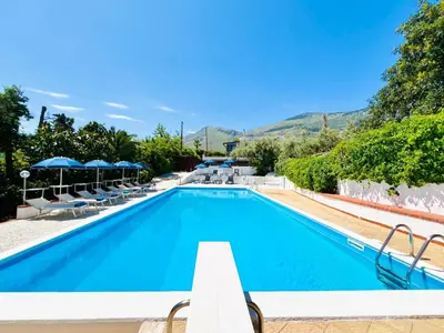 a pool at a hotel with chairs and umbrellas at Villa Giada in Carini