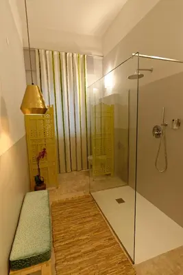 a bathroom with a glass shower with a bench at B&B Questa casa non e'un albergo in Palermo