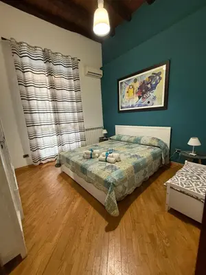 a bedroom with a bed and a blue wall at Casa nel Vicolo in Palermo