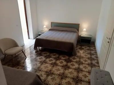 a bedroom with a bed and a chair in a room at Scopelos in Scopello