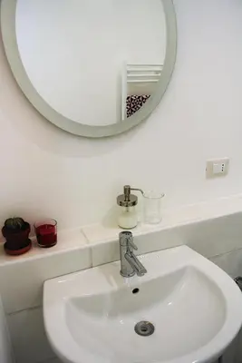 a bathroom with a white sink and a mirror at Be Central Rooms in Palermo