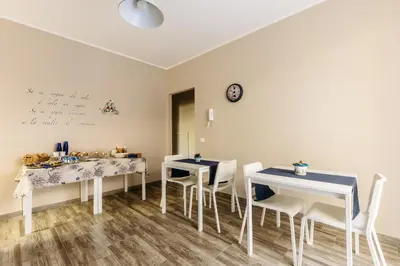 a dining room with two tables and chairs and a clock at B&B Medusa in Santa Flavia