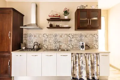 a kitchen with white cabinets and a sink at B&B Medusa in Santa Flavia