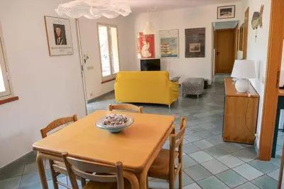 a dining room with a table and a yellow chair at Villa Bruna in Cefalù