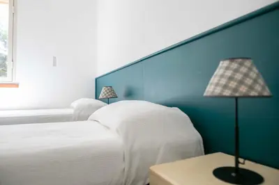 a bedroom with two white beds and a blue wall at Villa Bruna in Cefalù