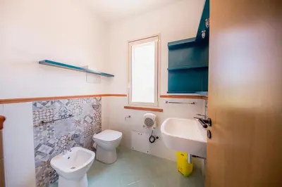 a bathroom with a toilet and a sink at Villa Bruna in Cefalù