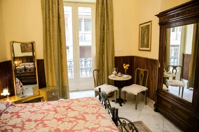 a bedroom with a bed and a table and a window at B&B Santa Caterina in Palermo
