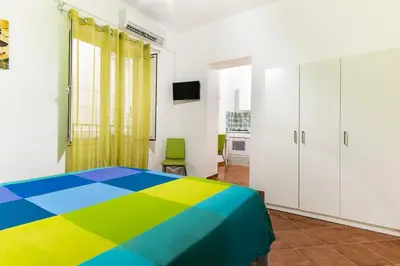 a bedroom with a rainbow bed and white cabinets at Madinah apartments in Palermo
